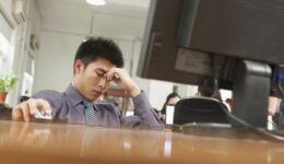 Overwhelmed - Exhausted businessman sitting in front of computer