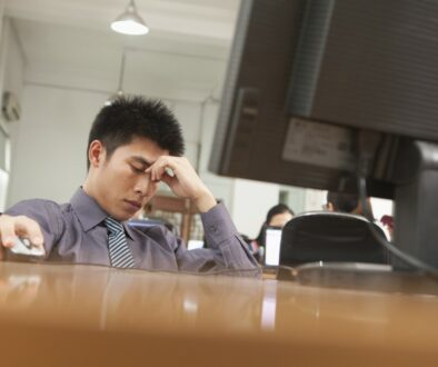 Overwhelmed - Exhausted businessman sitting in front of computer