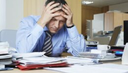 recession: Businessman sitting at desk with head in hands