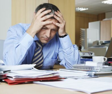 recession: Businessman sitting at desk with head in hands