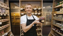 Think like a customer - Portrait of mid adult salesman holding jar of jam in grocery store